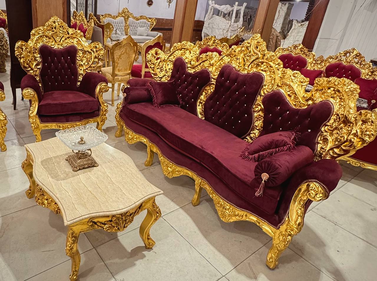 Sala com sofá e poltronas Luís XV em veludo bordô no showroom Unique Royal Styles